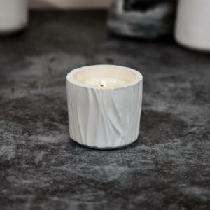 bougie artisanale parfumée en pot sculpté en plâtre blanc. Poids de la bougie : 110 grammes. Cire 100% végétale avec mèche en bois crépitante. Design élégant et raffiné, idéale pour une décoration moderne et un moment de détente parfumé. Bougie écologique fabriquée à la main avec des parfums de Grasse