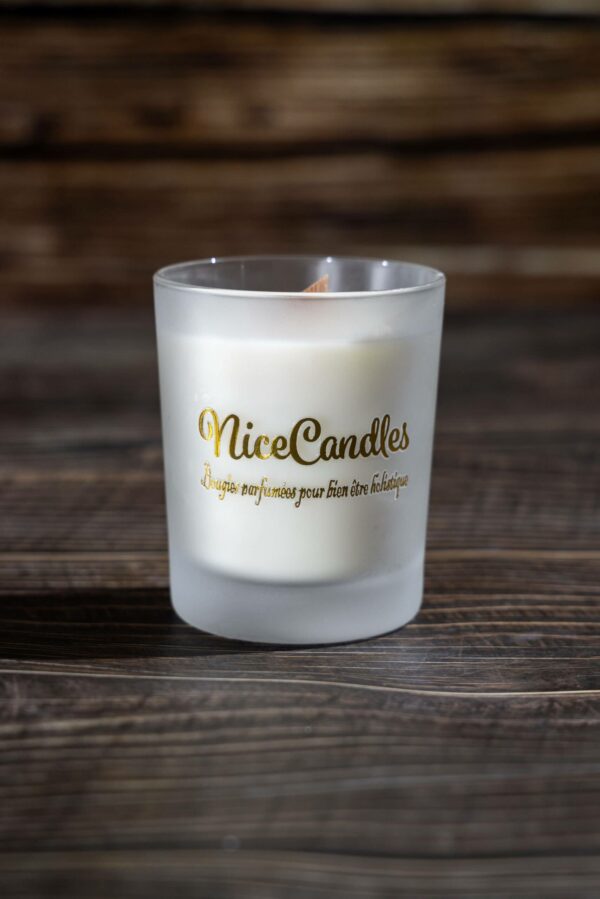 Bougie artisanale parfumée dans un élégant pot en verre mat, diffusant une fragrance raffinée de Grasse. Mèche en bois crépitante pour une expérience sensorielle apaisante.
