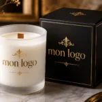 Bougie personnalisée sur mesure en verre mat blanc avec mèche en bois et logo doré, présentée avec son coffret noir premium assorti.